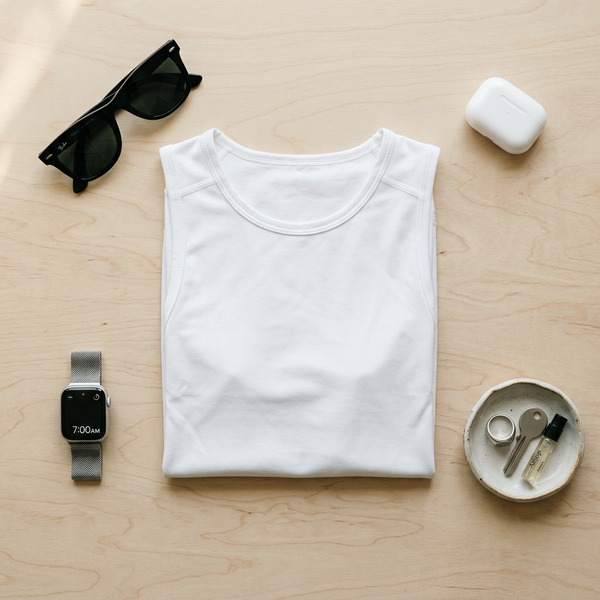 Plat d’accessoires avec un débardeur blanc IDEON : lunettes, montre, clés et écouteurs